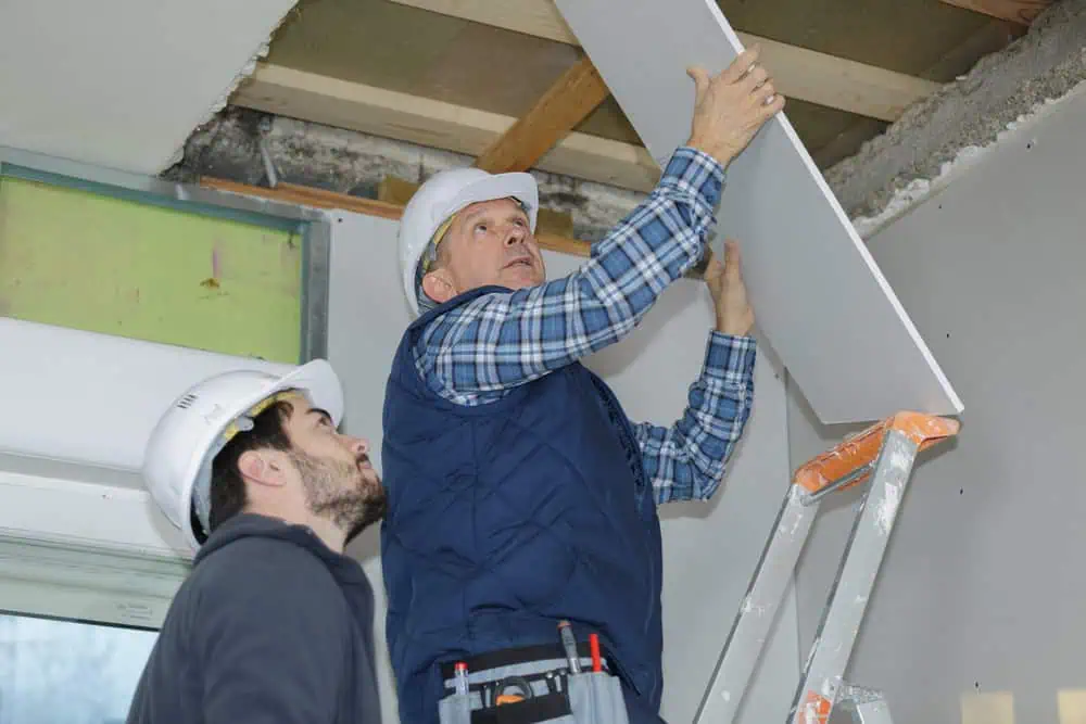 worker installing drywall